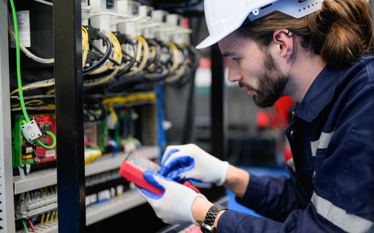 Professional technician checking and repairing part of automatic machine